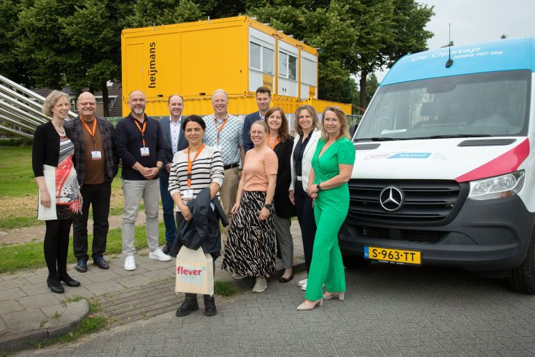 Groep personen voor een minibus.