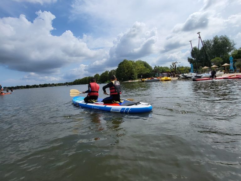 Twee kinderen op een sup op het water.