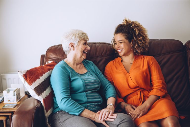 Twee vrouwen op de bank in gesprek met elkaar.