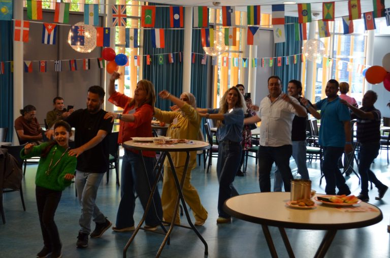 Bezoekers van het zomerfeest van Vluchtelingenwerk Welzijn Lelystad zetten spontaan een polonaise in.